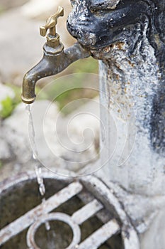 Old iron rusty faucet opened, with water flowing