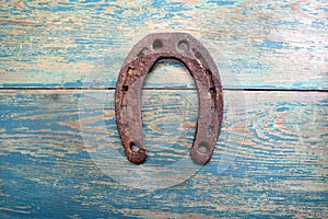 Old iron rusty metal horseshoe on weathered wood
