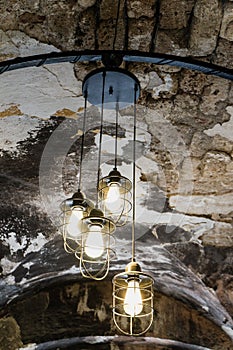 Old Iron Street Lantern, Black lamp for hang on the roof in cafe. Interior design of lamp. Yellow light bulb is illuminating and