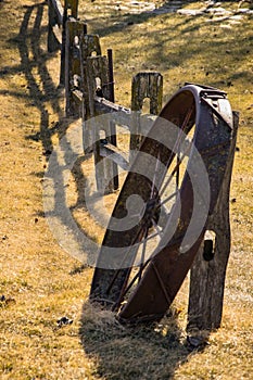 Old iron wagon wheel and wooden fence