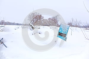 An old iron washstand is thrown in the middle of the field in winter and covered with snow