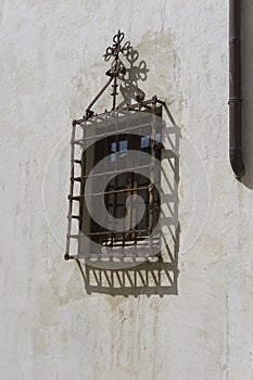 Old iron window with wooden edges on a Spanish street. Tradition