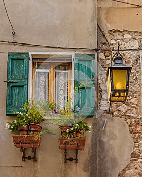 Old Italian facade window with shutters and flowers