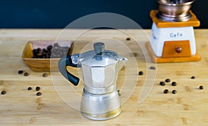 Old Italian Moka coffee maker, manual coffee grinder in the background