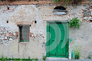 Old italian stone house front with green door