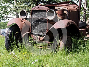 Old Jalopy Rusting Away In Tall Grass