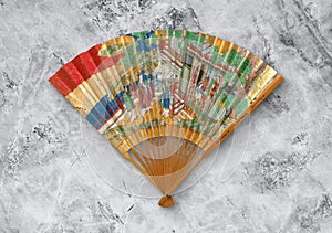 Old Japanese folding fan from early 19th century on gray background