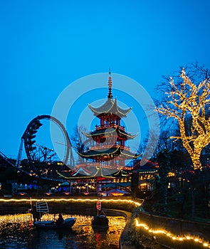 Old japanese pagoda and rollercoaster in Tivoli gardens Copenhagen