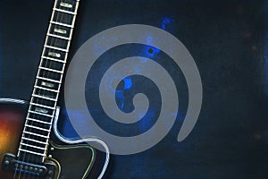Old, jazz electric guitar on a blue grunge background. Copy space. Background for music festivals, concerts. Musical education.