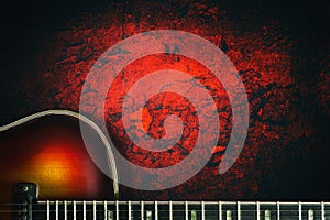 Old, jazz electric guitar on a red grunge background. Copy space. Background for music festivals, concerts. Musical education.