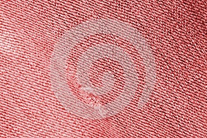 Old jeans texture close up, top view. Denim background, red color toned