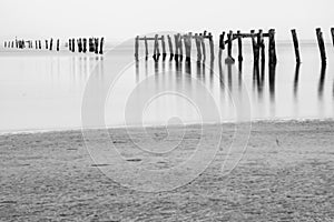 Old jetty at beach on grey a day