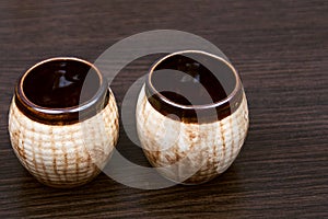 Old jug on brown background. brown porcelain tea cups. Ceramic cans. small jars. Brown clay dishes. clay pots made of clay