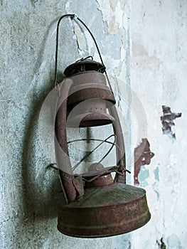 An old kerosene lamp hanging on the shabby wall.