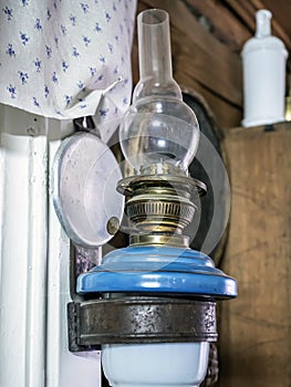 old kerosene lamp hangs on the wall