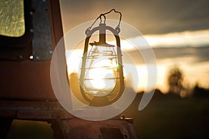 The old kerosene lantern on a tractor at sunset