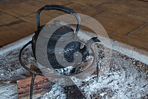 Old kettle placed on a firewood stove