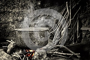Old kettle sitting on hot fire