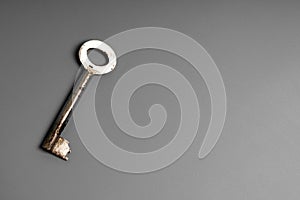 Old key on a gray surface, top view photo