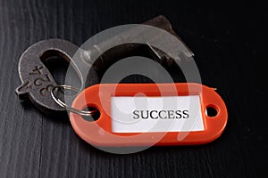 An old key with an inscription on a black table. Accessories and symbol referring to the word in the description of the key