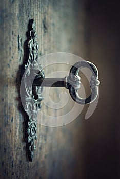 Old key in keyhole, macro shot. Gothic style. Key to knowledge. Concept and Idea for History, education, business, security,