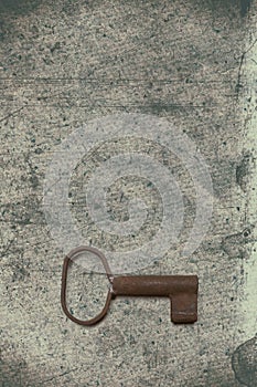 Old key on the old textured paper with natural patterns