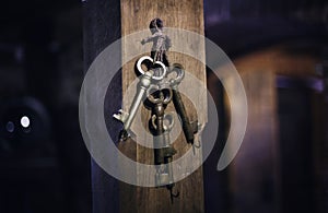 Old keys on a column, antique wood background