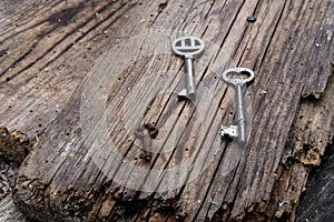 Old keys of different sizes on rustic weathered wood planks