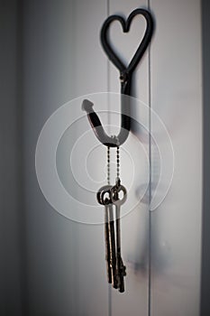 Old keys hanging on a white wall.