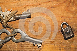 Old keys with small lock  on wooden background