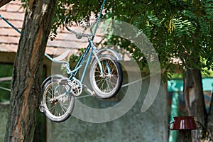 Old kid`s bicycle hang on rope
