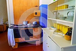 Old kitchen with metal oven and utensils from bygone eras,