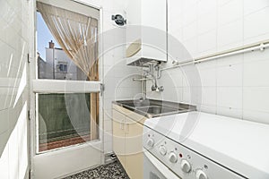 old kitchen with wooden door to a terrace, natural gas