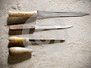 Old knives and other tools on a concrete floor