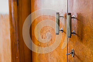 Old knob, lock and handles on an old wooden furniture. Visible also lock and a key on an old decayed wooden door