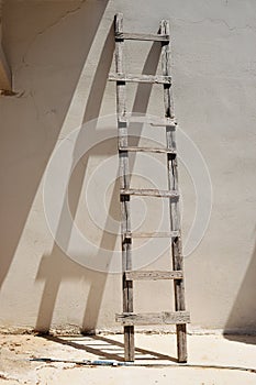 Old ladder at the empty wall of house