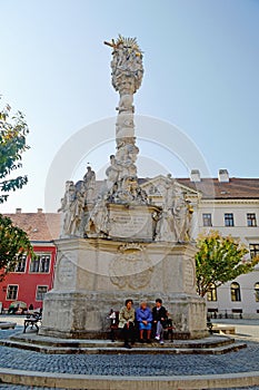 3 old ladies sat at the base of the Trinity column chatting Sopron Hungary