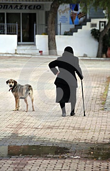 Old lady accompanied by dog at a Greek village