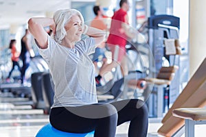 Old lady doing exercises on fitness ball