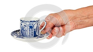 Old lady (hand) with an antique Dutch cup in Delfts blue, Holland