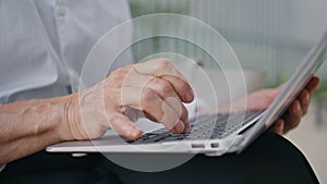 Old lady hands typing laptop keyboard close up. Unknown mature lady writing text