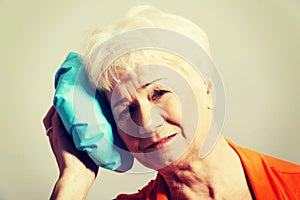 An old lady with ice bag by her head