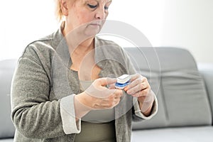 Old lady measuring her oxygen saturation with a pulse oximeter. Health concept