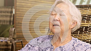 Old lady pointing to the camera, seated telling stories, having a conversation, expressions of a old lady