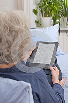 Old lady reading digital book