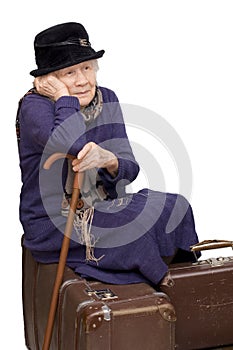 The old lady sits on a suitcase