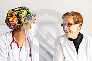 Old lady smiling while talking to the nurse