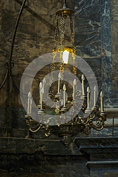 Old lamp hanging from the ceiling with a lit bulb