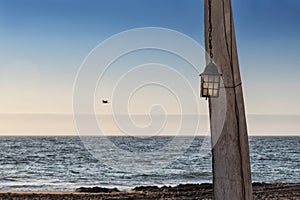 Old lamp next to the coast, idyllic scene from the ancient times of fishing. Africa. Angola. Namibe