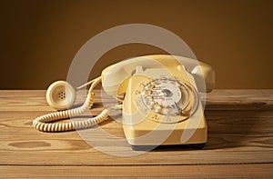 Old landline phone as a decoration in the room on a wooden table